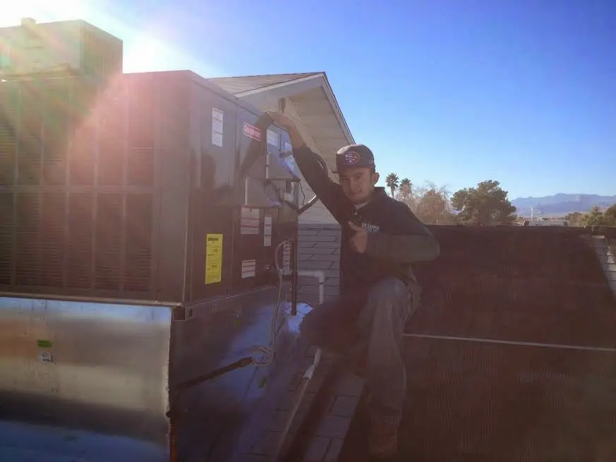 HVAC technician performing Air Duct Repair on a rooftop unit in Oil City